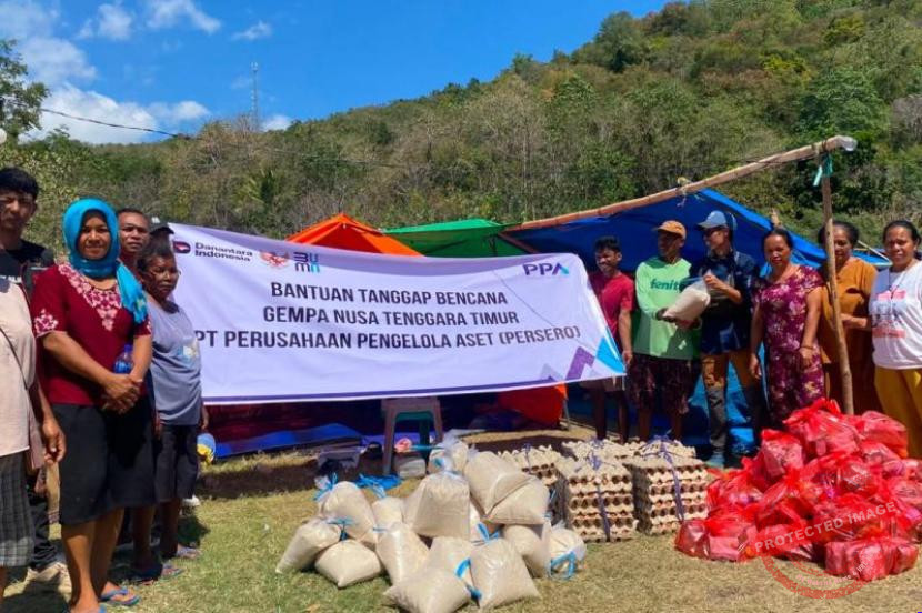 Petugas bersama relawan menyalurkan bantuan logistik dari truk untuk korban gempa NTT