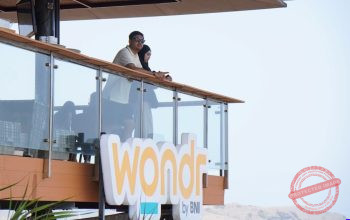 Apresiasi Nasabah — Nasabah BNI menonton MotoGP dari Bukit 360 Mandalika dengan panorama lintasan dan kawasan Mandalika